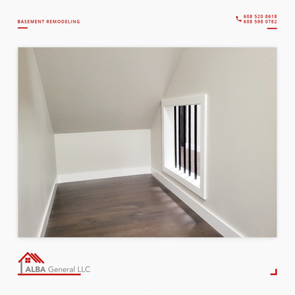 A neatly finished basement nook with dark wood flooring and a decorative vent, part of a remodeling project by Alba General in Madison, WI.