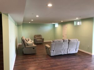 A spacious, newly finished basement renovation by Artstone Exteriors & Renovations, featuring modern flooring and lighting in Myersville, MD.