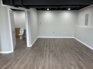 A newly finished basement renovation with new flooring and painted walls by Gama Home & Lawn Services LLC in Kansas City, MO.