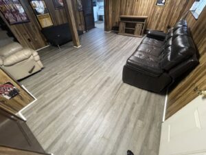 A completed basement renovation featuring new flooring and wood paneling by Ridgely Home Services LLC in Pittsburgh, PA.