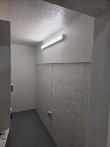 A newly finished basement room with painted walls and new fluorescent lighting installed by King Electric Service, LLC in Pittsburgh, PA