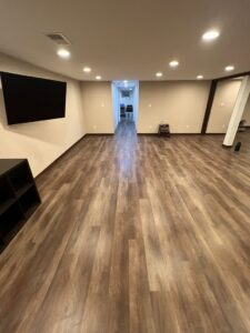 A finished basement showcasing new vinyl plank flooring installed by D E Custom Floors in Waukesha, WI.