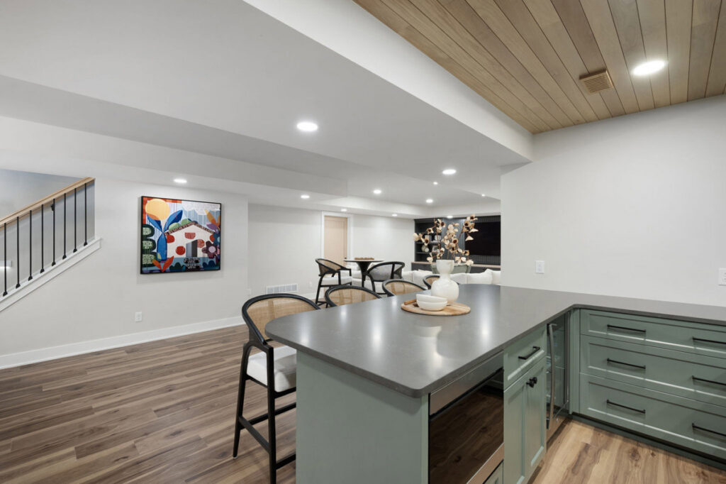 A beautifully finished basement featuring a modern bar area and staircase by J Brothers Design- Build- Remodel, Inc. in Corcoran, MN