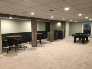 A beautifully finished basement with a pool table and bar area, completed by Pioneer Basement Solutions in Canton, OH.