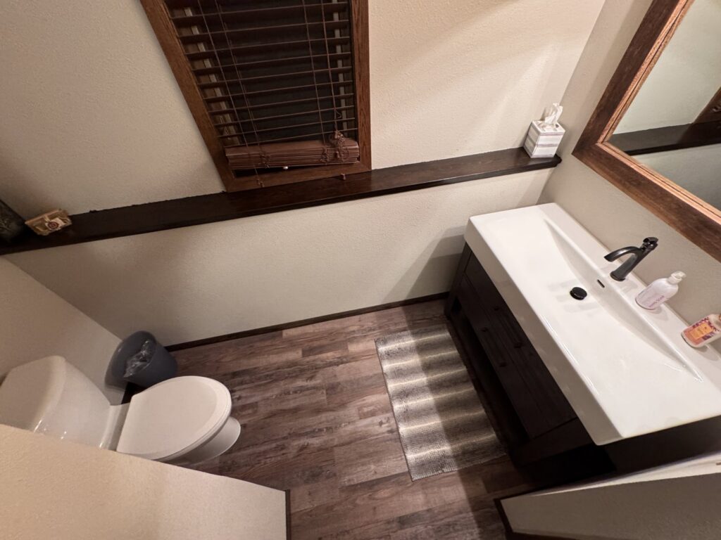 A finished bathroom with new flooring, vanity, and toilet installed by Hawk Handyman Services in West Fargo, ND