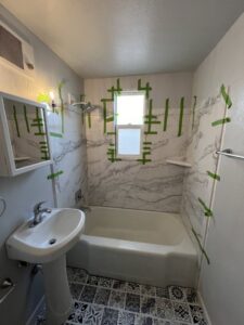 A beautifully finished bathroom renovation with new shower panels and floor tiles by High Plains Craftsmen in Cheyenne, WY.