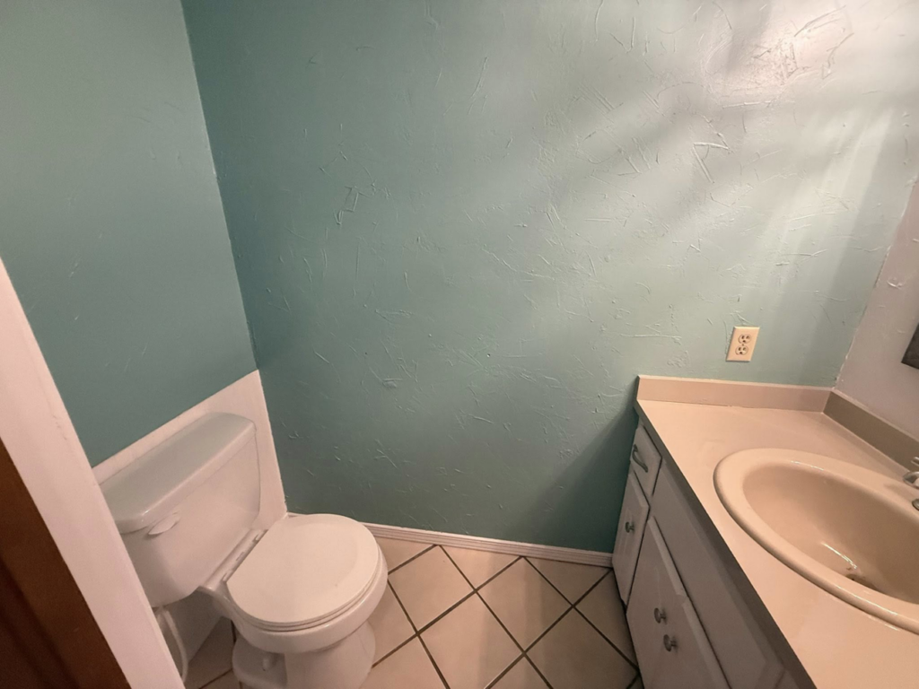 A completed bathroom renovation featuring a toilet, vanity, and freshly painted walls by Duane Moss Painting in Oklahoma City, OK.