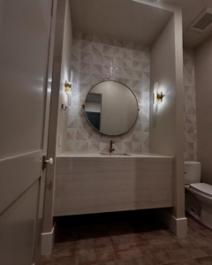 A finished bathroom vanity area with a tiled accent wall and modern fixtures by Orange Door Custom Coatings in Phoenix, AZ.