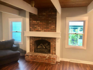 A beautifully finished brick fireplace and new windows by EXCEL Handyman in Raytown, MO.