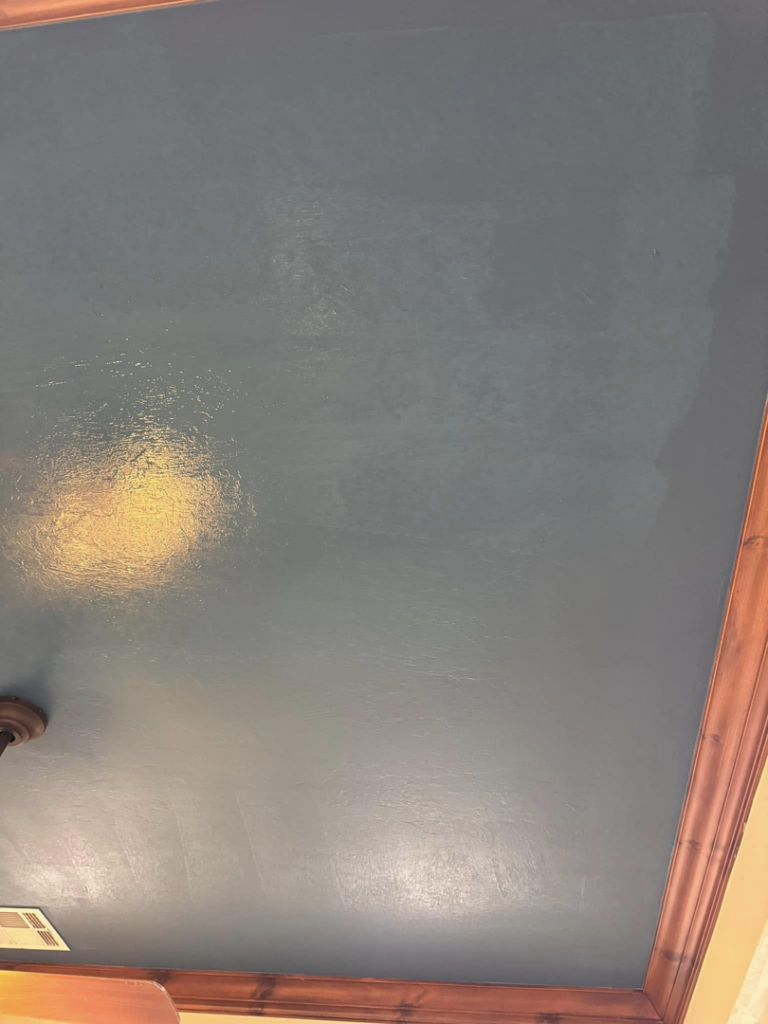 A newly painted dark blue ceiling with elegant crown molding, completed by Sanders Construction & Handyman Services, LLC in Oklahoma City, OK.