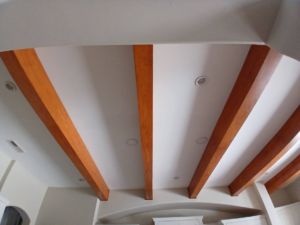 Finished ceiling with decorative wooden beams and recessed lighting by Southeastern Painting & Drywall in Wilmington, NC