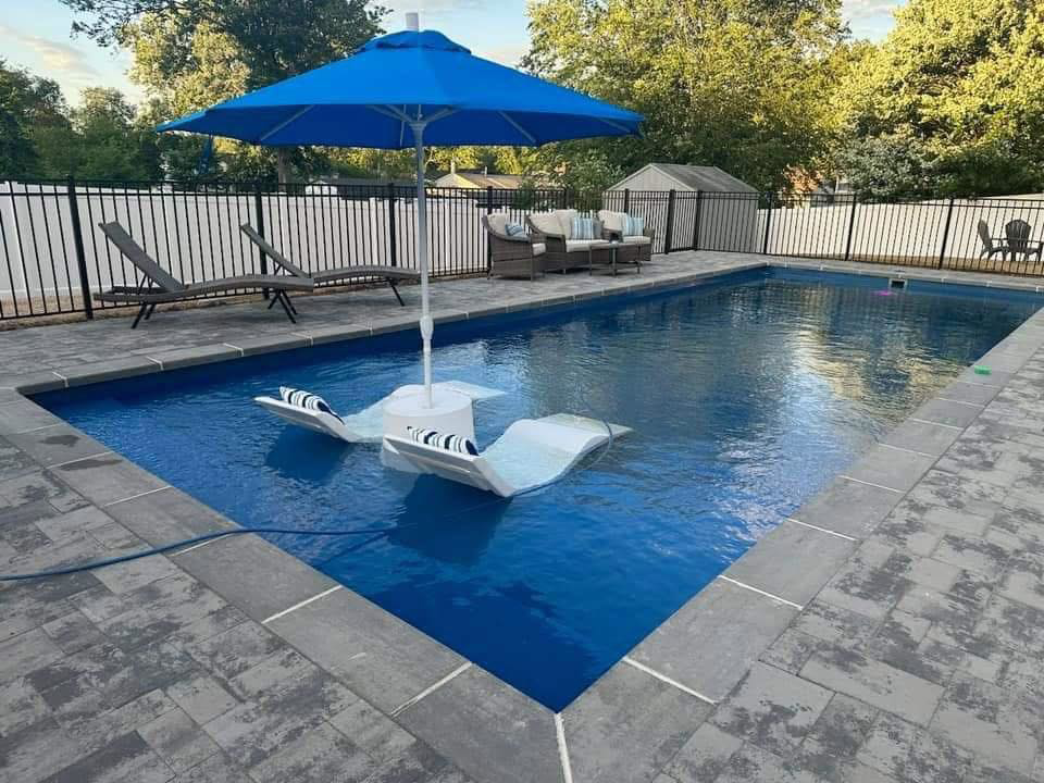 A beautifully finished composite pool with paver patio and fence by Composite Pools USA in Newfield, NJ.