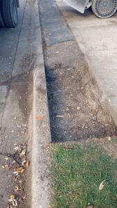 A finished concrete curb with a small trench, showcasing general contractor curb work by National Kurb Kut in Naperville, IL.