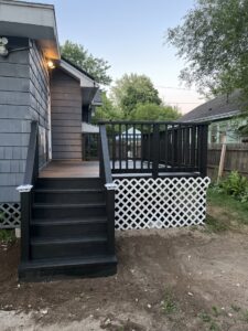 A newly completed deck with dark railings and white lattice skirting by TD Estimating Group LLC in Springfield, MA.