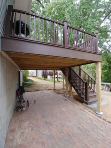 A completed outdoor deck with a brick patio area underneath, constructed by Custom Remodeling Inc. in Houston, TX.
