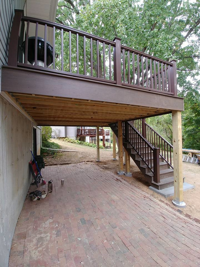 A completed outdoor deck with a brick patio area underneath, constructed by Custom Remodeling Inc. in Houston, TX.