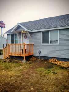 Completed wooden deck and new siding on a house exterior by Investment Handyman Services in Pocatello, ID