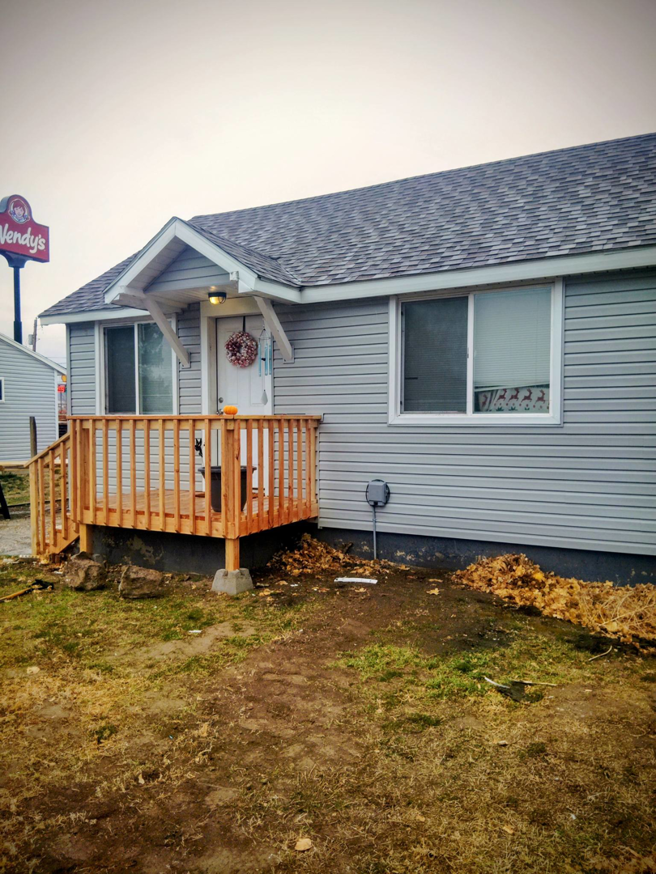 Completed wooden deck and new siding on a house exterior by Investment Handyman Services in Pocatello, ID