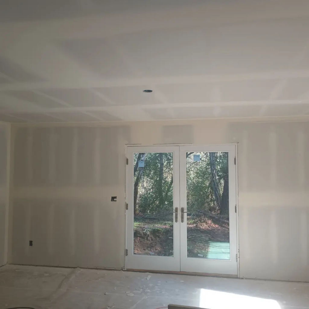 A room with newly finished drywall installation and French doors, completed by JLSL Drywall LLC in Salem, OR.