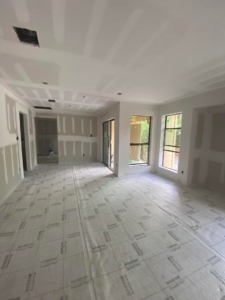 A newly finished room with expertly installed and taped drywall on walls and ceiling, showcasing interior construction by TechPro Constructions in Houston, TX.