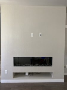 A finished wall installation with an electric fireplace and TV mounting area by The Foundation Guys in Lakewood, CO