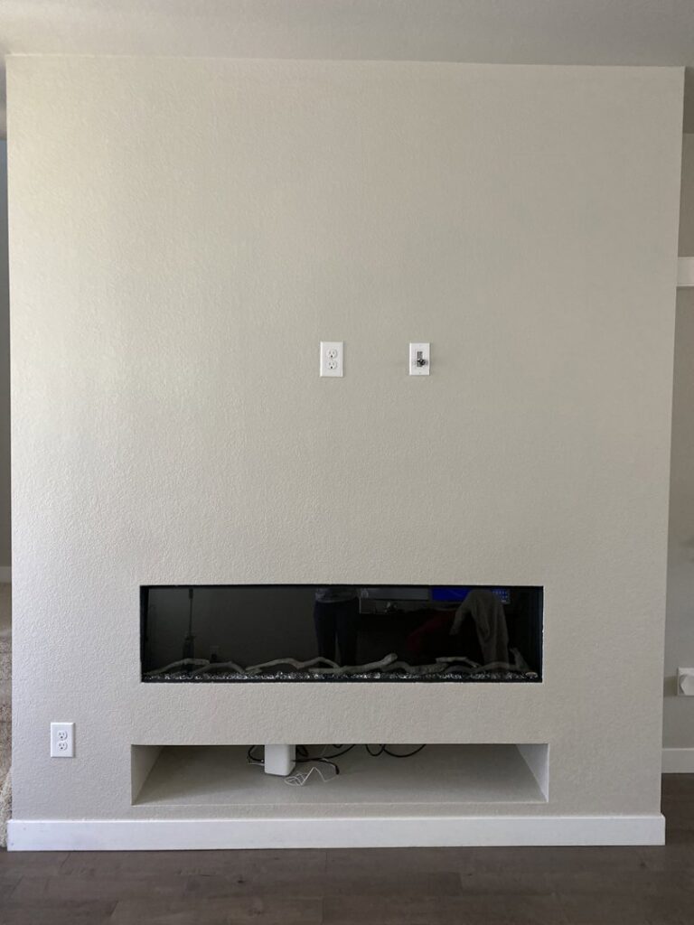 A finished wall installation with an electric fireplace and TV mounting area by The Foundation Guys in Lakewood, CO