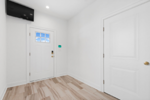 A finished entryway with new flooring and a white door, part of a renovation by EK Construction, LLC in Philadelphia, PA