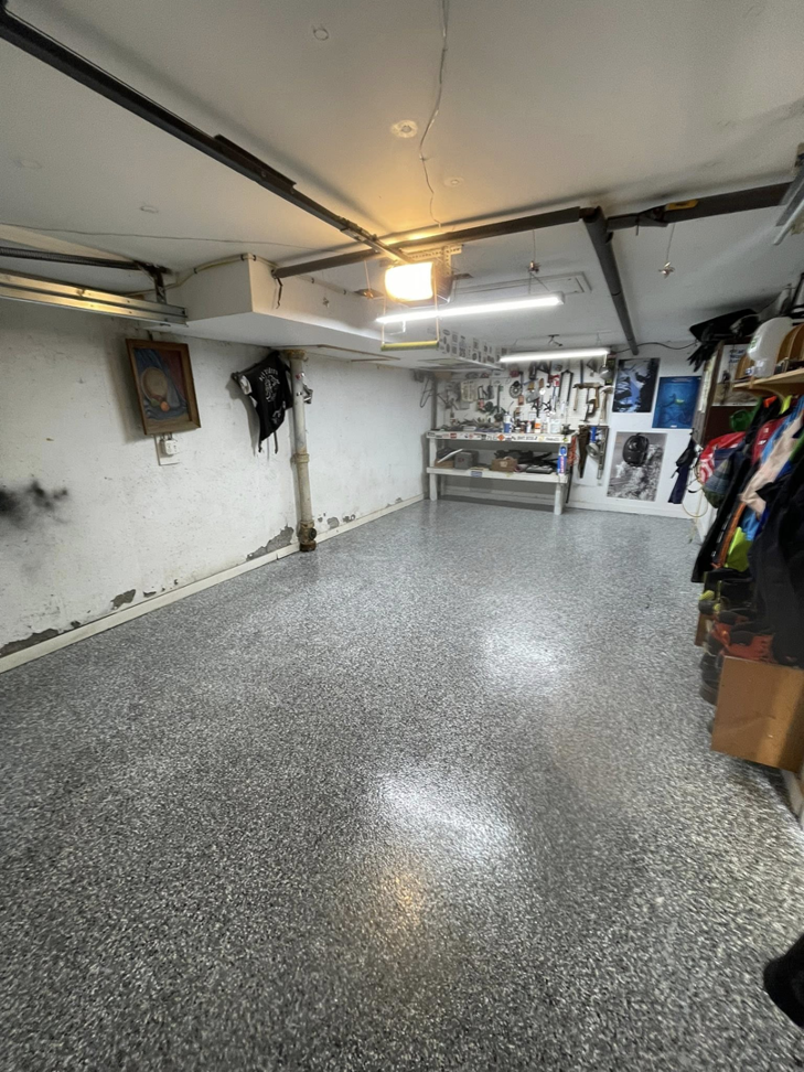 A newly installed speckled epoxy garage floor by Epoxy Evolution, a general contractor in Albany, NY.