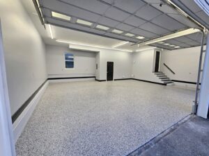 A spacious, newly finished garage with an epoxy floor and freshly painted walls, a handyman service by Randy Overacre Painting Company in Virginia Beach, VA.