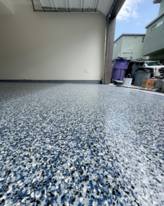 A newly finished garage floor with blue and grey speckled epoxy coating by Apex Custom Coatings in Middleton, WI