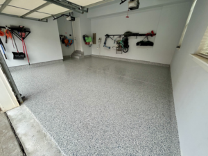 A newly finished garage with a speckled epoxy floor coating by Garage Upgrade Pros in Fort Mill, SC.