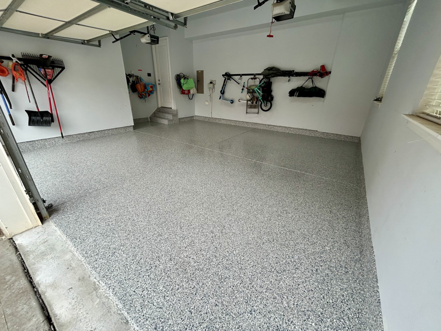 A newly finished garage with a speckled epoxy floor coating by Garage Upgrade Pros in Fort Mill, SC.