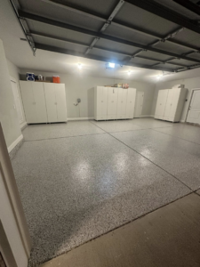 A newly installed grey speckled epoxy garage floor with storage cabinets by Galaxy Epoxy in Madison, AL.