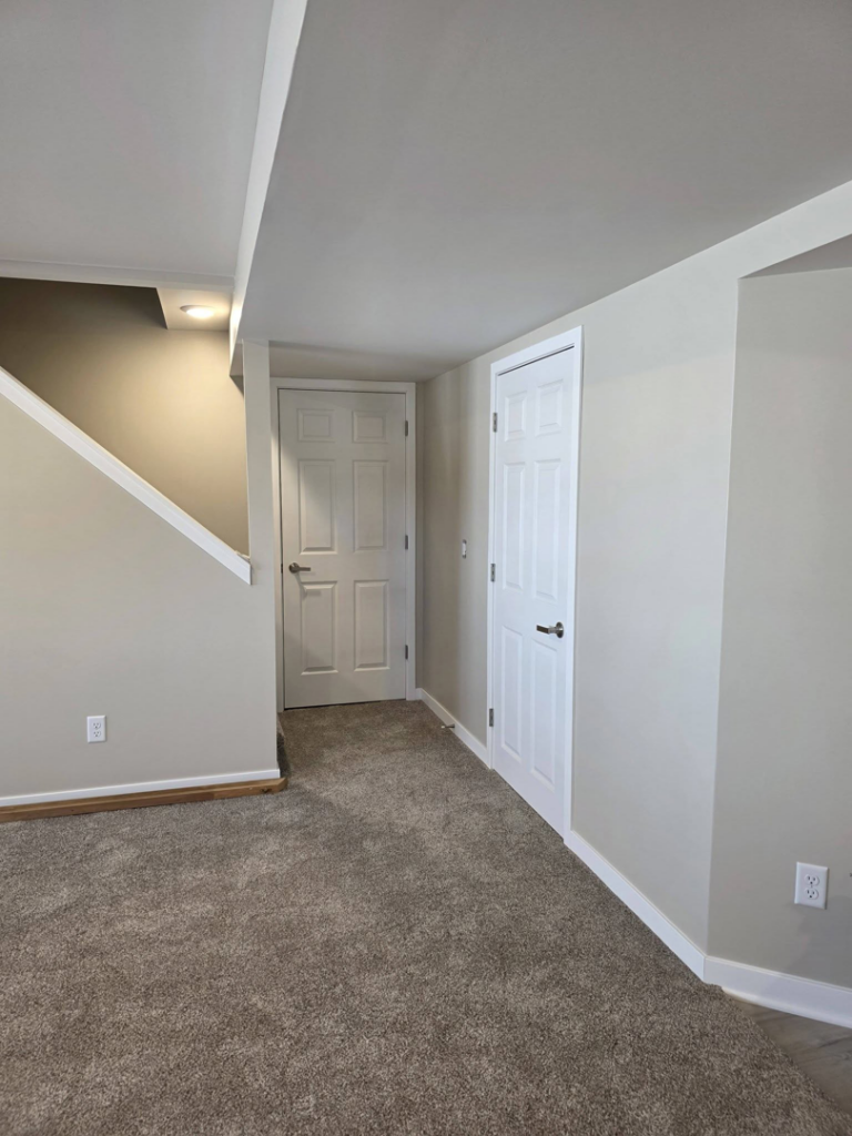A finished hallway featuring new carpet, painted walls, and new doors installed by Rosenthal Remodeling in Milton, WI.