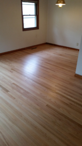 A pristine, finished hardwood floor in an empty room with a window by Birdseye Hardwoods LLC in Portland, OR