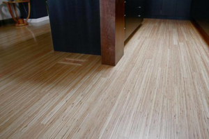 A sleek, finished hardwood floor in a modern room with a dark accent wall by Birdseye Hardwoods LLC in Portland, OR