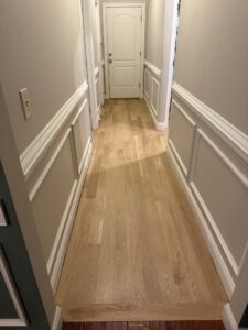A newly installed light hardwood floor in a residential hallway by Franco's Hardwood Flooring in Durham, NC.