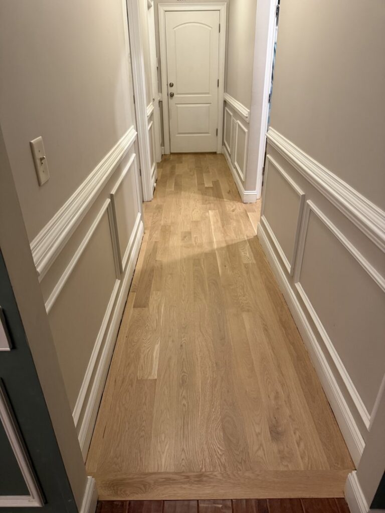 A newly installed light hardwood floor in a residential hallway by Franco's Hardwood Flooring in Durham, NC.