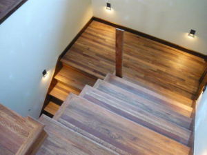 A beautifully finished hardwood staircase and landing with modern wall lights by Birdseye Hardwoods LLC in Portland, OR