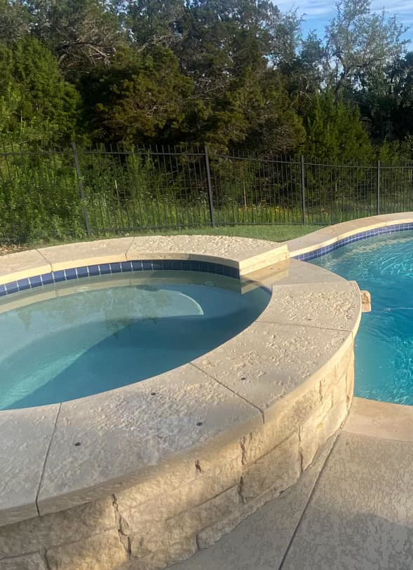 A close-up of a finished hot tub with new coping and tiling, part of a pool project by 5 Daughters Total Outdoors in Austin, TX.