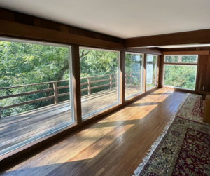A beautifully finished interior room with large windows and a wooden deck view by Imagine It Home Improvements Co. in Bethlehem, PA.