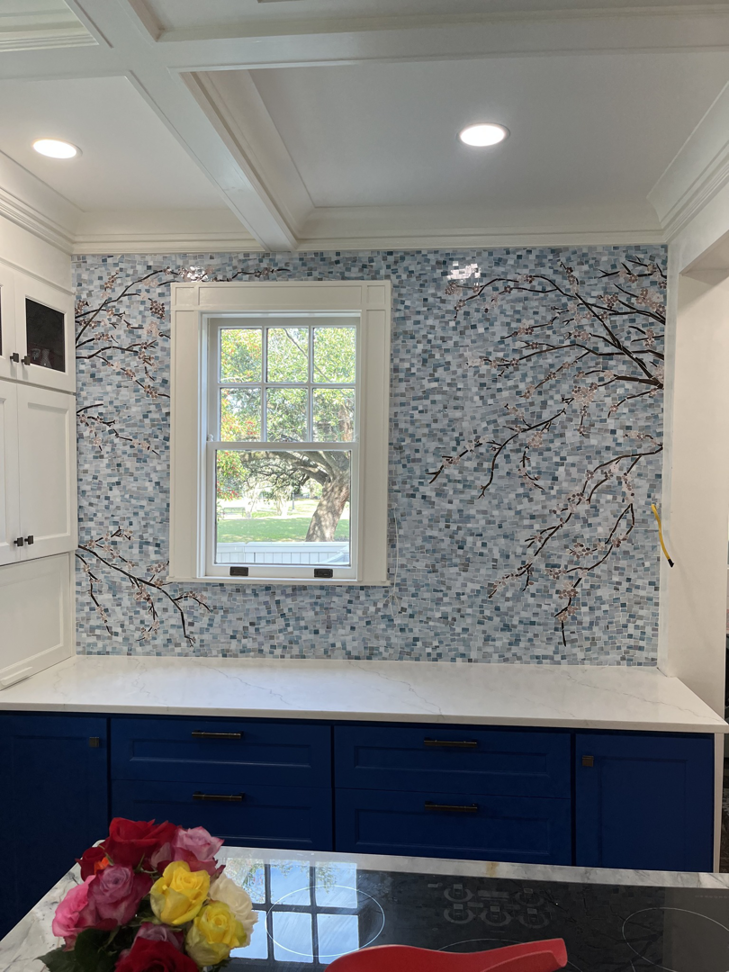 A beautifully finished kitchen mosaic tile backsplash with a cherry blossom design by Ayres Endeavors, LLC in New Orleans, LA.