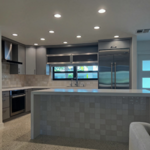 A finished kitchen remodel showcasing new tile backsplash and island tiling by Broward Tile Guys in Pompano Beach, FL.