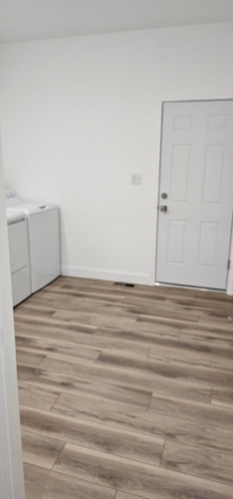 A newly finished laundry room interior with wood-look flooring by Susquehanna Valley Builders in Harrisburg, PA.