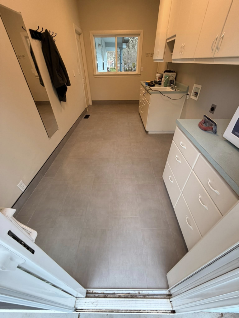 A newly installed tile floor in a bright laundry room completed by Connolly Tile LLC in Medford, OR.
