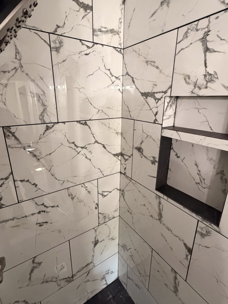 A beautifully finished shower with white marble-look tiles and a built-in niche by Connolly Tile LLC in Medford, OR.