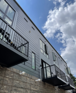 A finished modern building exterior with dark siding and black metal balconies by New Life Custom Carpentry in Livonia, MI.