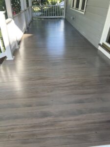 A newly finished outdoor deck or porch with composite wood-look flooring, completed by Home pro handyman llc in Olathe, KS