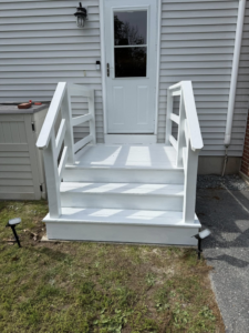 A fully painted white outdoor wooden staircase with railings, completed by Daniels Handyman Services in Warwick, RI.