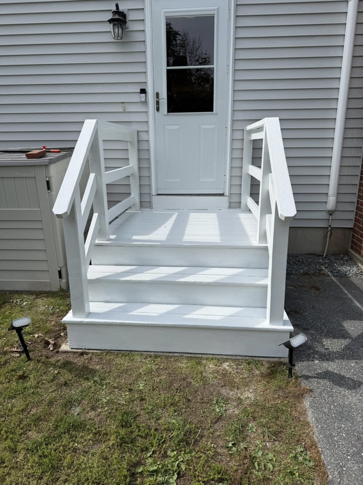 A fully painted white outdoor wooden staircase with railings, completed by Daniels Handyman Services in Warwick, RI.